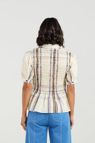 Woman wearing a plaid shirt and blue pants on a white background