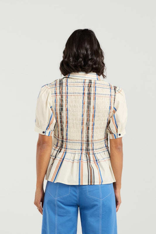 Woman wearing a plaid shirt and blue pants on a white background