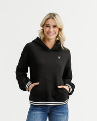 Woman wearing a black hoodie with a small logo on a white background