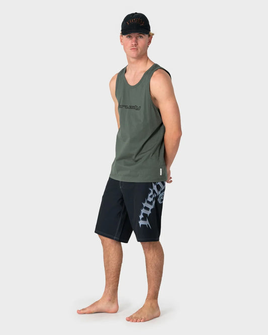 Man wearing a green tank top and black shorts with visible branding on a white background