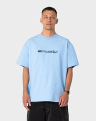 Person wearing a light blue t-shirt with a logo on a plain background