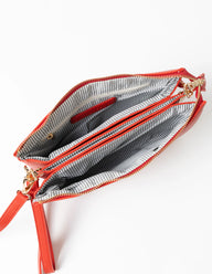 Open red clutch bag with gold zipper on a white background