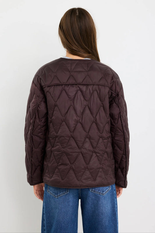 Person wearing a brown quilted jacket on a white background