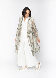Woman wearing a white outfit with a patterned jacket on a white background