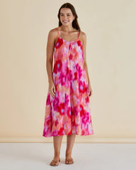 Woman wearing a colorful floral dress against a beige background