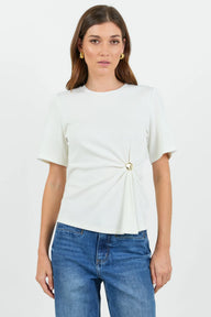 Woman wearing a white t-shirt with a knot detail and blue jeans on a white background