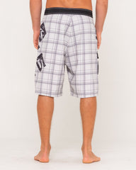 Person wearing plaid shorts with a brand logo on a white background