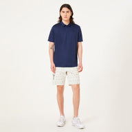 Person wearing a navy blue polo shirt and white shorts on a white background