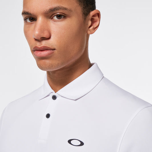 Man wearing a white polo shirt with a brand logo on a light gray background