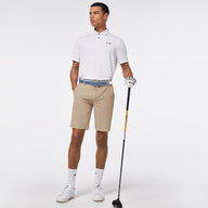 Man in golf attire holding a golf club on a white background