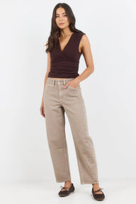 Woman wearing a brown top and beige pants on a white background