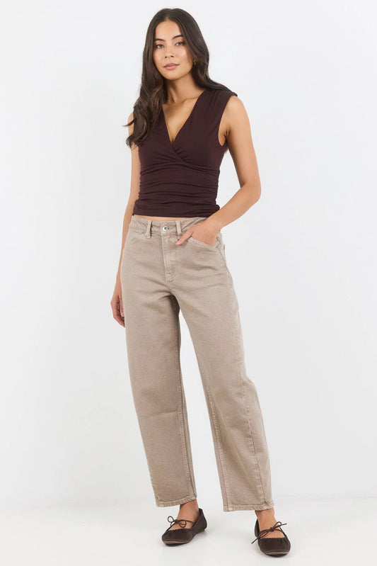 Woman wearing a brown top and beige pants on a white background