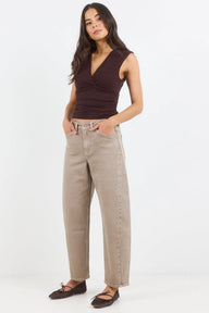 Woman wearing a brown top and beige pants on a white background
