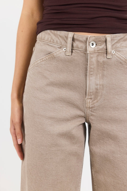 Beige pants worn by a person on a white background