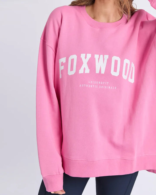 Pink sweatshirt with 'FOXWOOD' printed on it against a light gray background