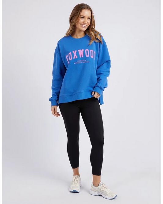 Woman wearing a blue sweatshirt with 'FOXWOOD' printed on it against a white background