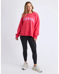 Person wearing a red 'Foxwood' sweatshirt and black leggings on a light gray background