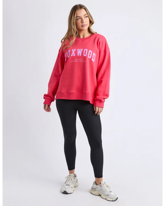 Person wearing a red 'Foxwood' sweatshirt and black leggings on a light gray background