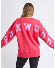 Person wearing a red sweatshirt with 'FOXWOOD' printed on the back against a white background