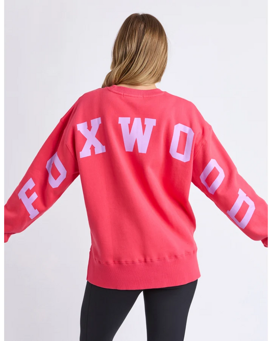 Person wearing a red sweatshirt with 'FOXWOOD' printed on the back against a white background