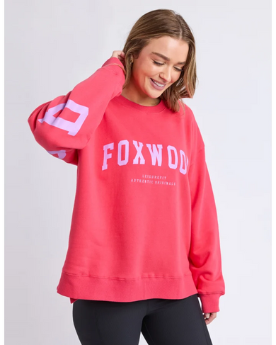 Person wearing a red 'Foxwood' sweatshirt and black leggings on a light gray background