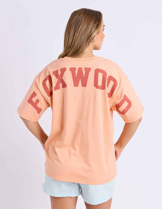 neon peach tee with pink writing and foxwood logo front and back