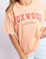 neon peach tee with pink writing and foxwood logo front and back