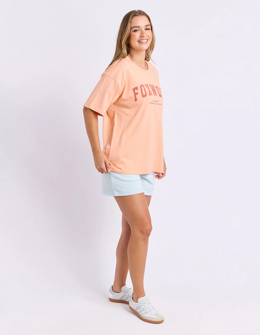 neon peach tee with pink writing and foxwood logo front and back