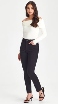 Woman wearing a white off-shoulder top and black jeans on a white background