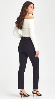 Woman wearing a white off-shoulder top and black pants on a white background