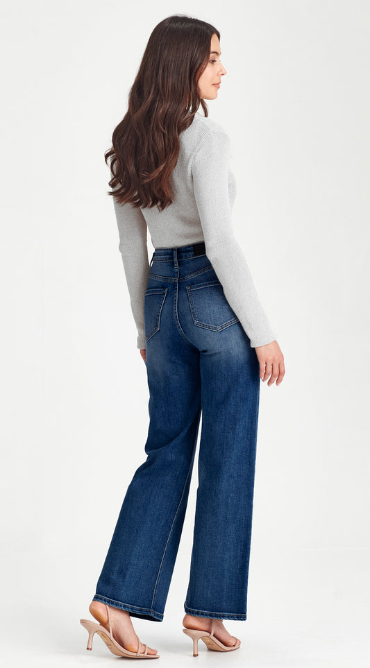 Woman wearing blue jeans and a white top on a white background
