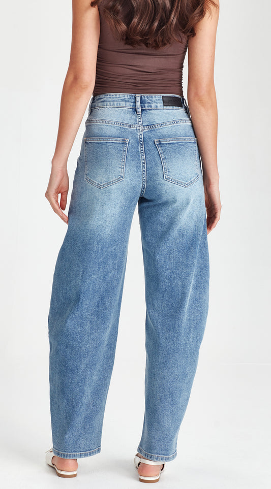Person wearing a brown tank top and light blue jeans on a white background