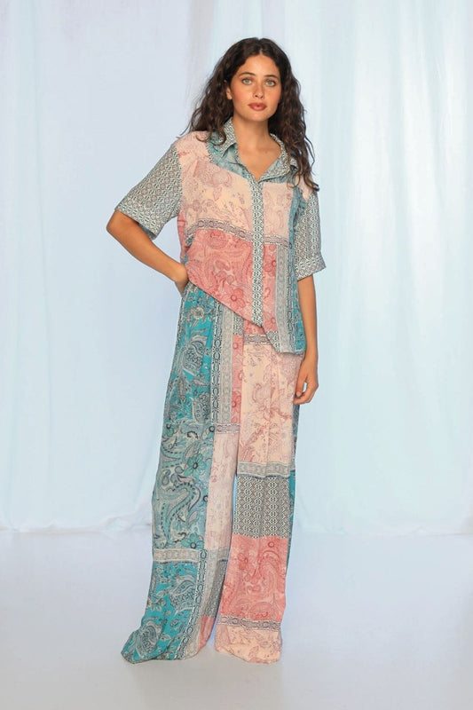 Woman wearing a colorful patterned outfit against a white background