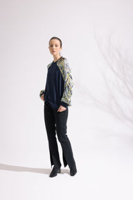 Person wearing a black outfit with floral sleeves against a white background