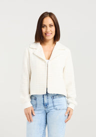Woman wearing a white blouse and light blue jeans on a plain background