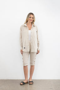 Woman wearing a beige outfit with a white background