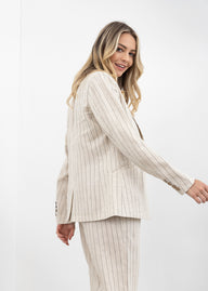 Woman wearing a beige pinstripe suit on a white background