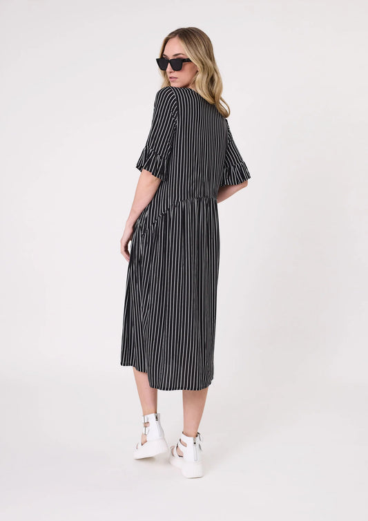 Woman wearing a black and white striped dress on a white background