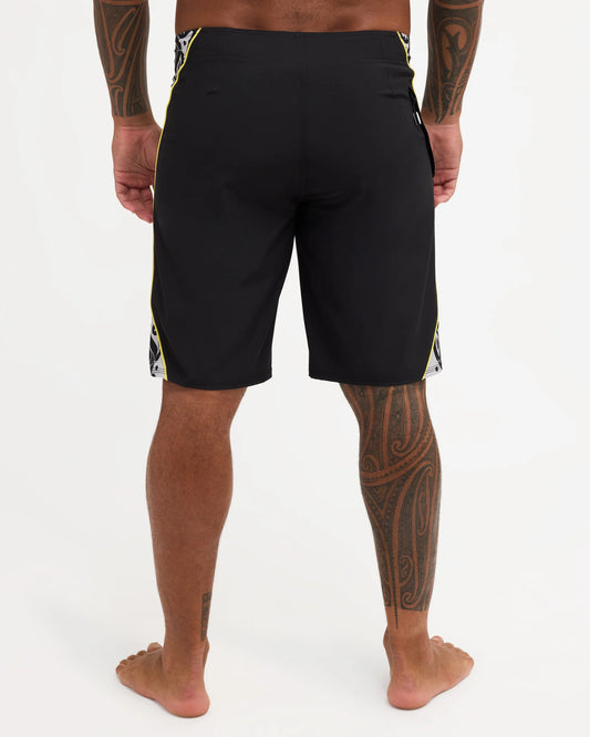Black boardshort with yellow detail and black and white maori design 