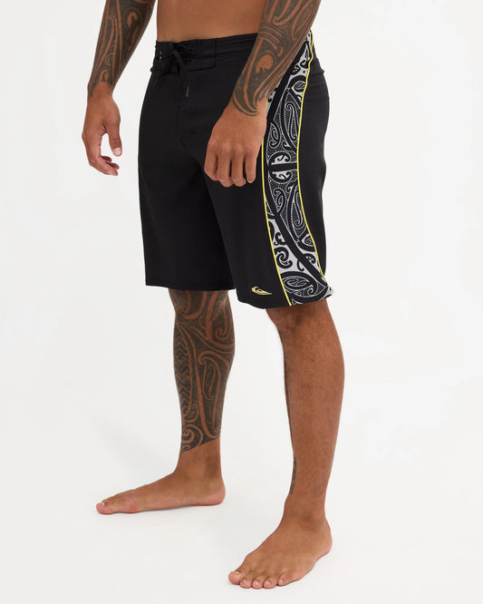 Black boardshort with yellow detail and black and white maori design 