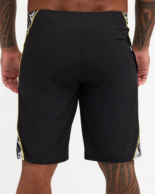 Black boardshort with yellow detail and black and white maori design 