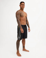Black boardshort with yellow detail and black and white maori design 