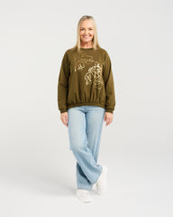 Woman wearing an olive green sweatshirt with a graphic design on a white background