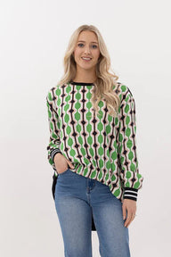 Woman wearing a patterned sweater and blue jeans on a white background
