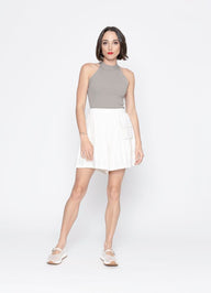 Woman wearing a gray top and white skirt on a white background