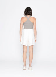 Woman wearing a gray top and white skirt on a white background