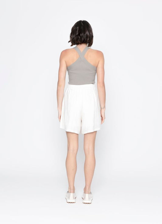 Woman wearing a gray top and white skirt on a white background
