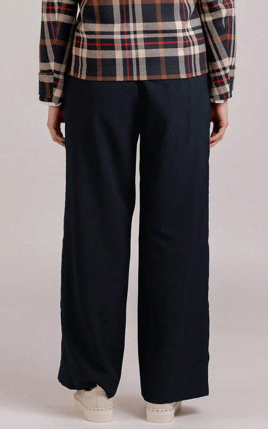 Person wearing black wide-leg pants with a plaid shirt on a plain background