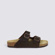 A dark brown double-strap sandal with adjustable buckled straps, a cork midsole, and a black outsole, shown in profile against a light gray background.