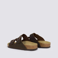 A pair of dark brown double-strap slide sandals with cork-look midsoles, shown from a side angle on a light gray background.